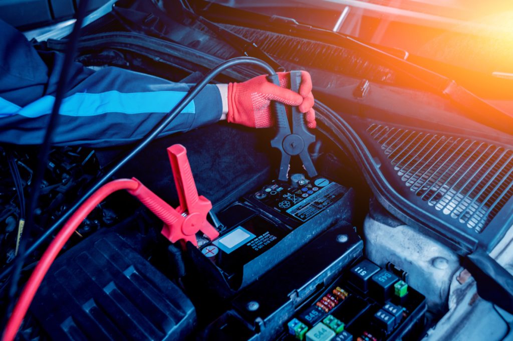 An image of a technician jumping a car battery.
