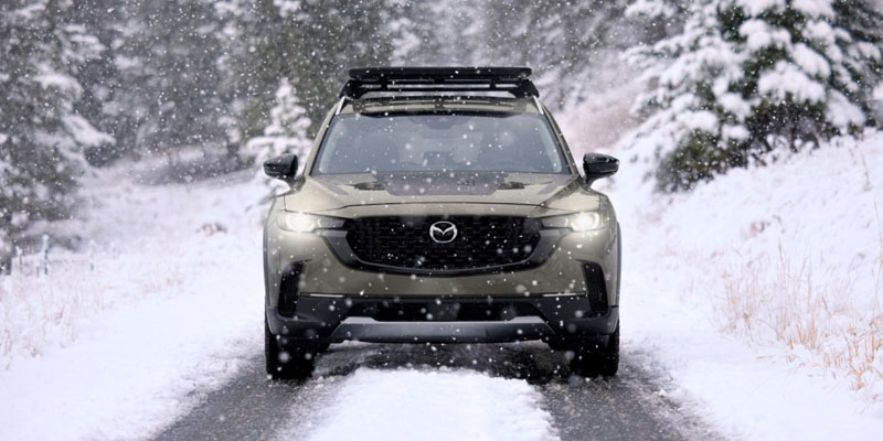 A green Mazda SUV drives down a snowy road near Shiloh, IL
