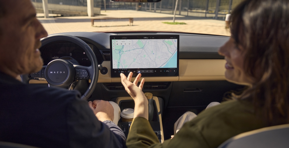 Older couple exploring the advanced touchscreen features of a Mazda
